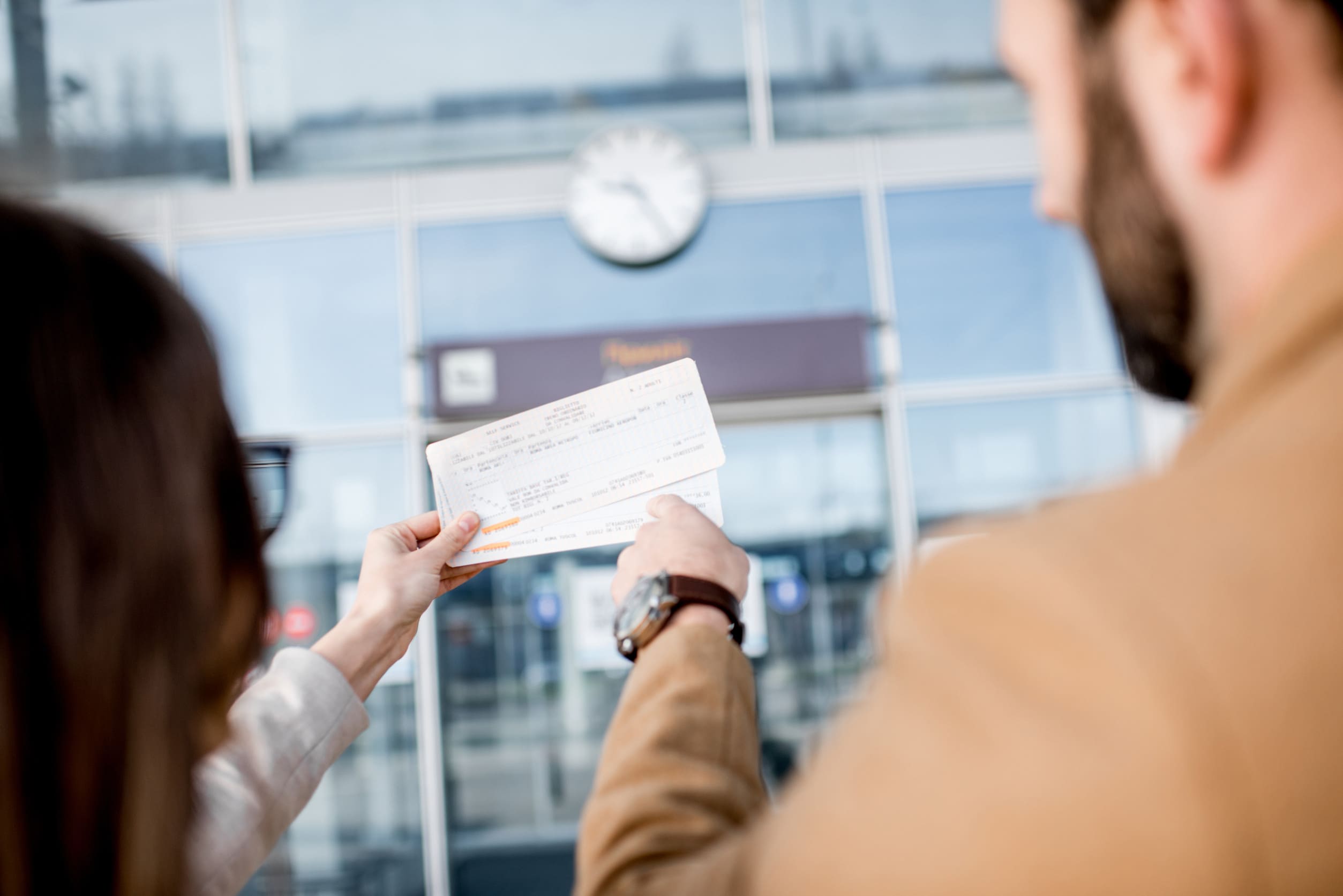 Business Couple Holding Tickets In Front Of The Airport Entrance Outdoors