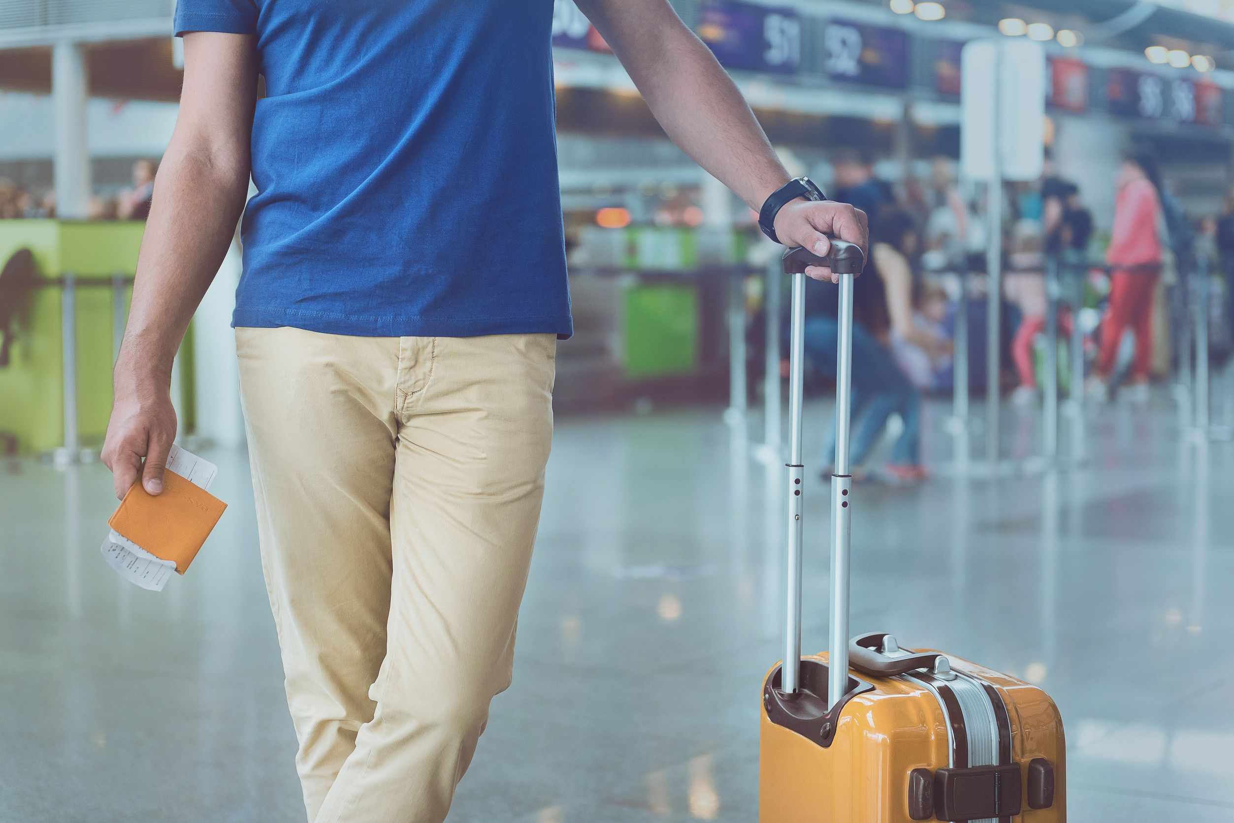Male Passenger Putting Hand On Baggage Handle And Holding Tickets