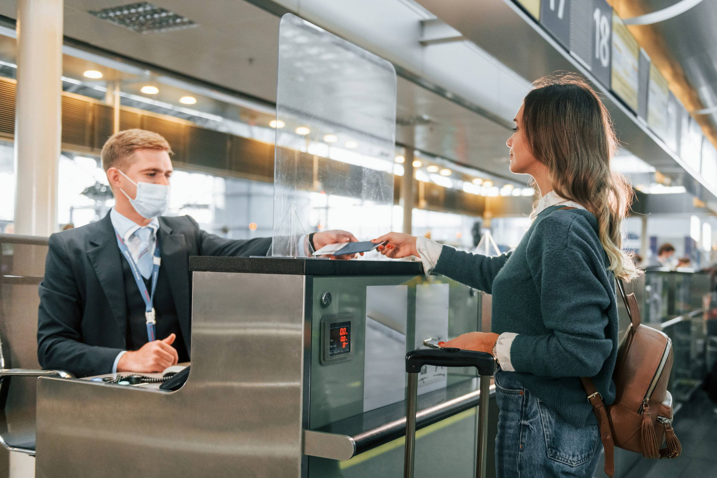 Standing By The Table With Employee Young Female Tourist Is In The Airport