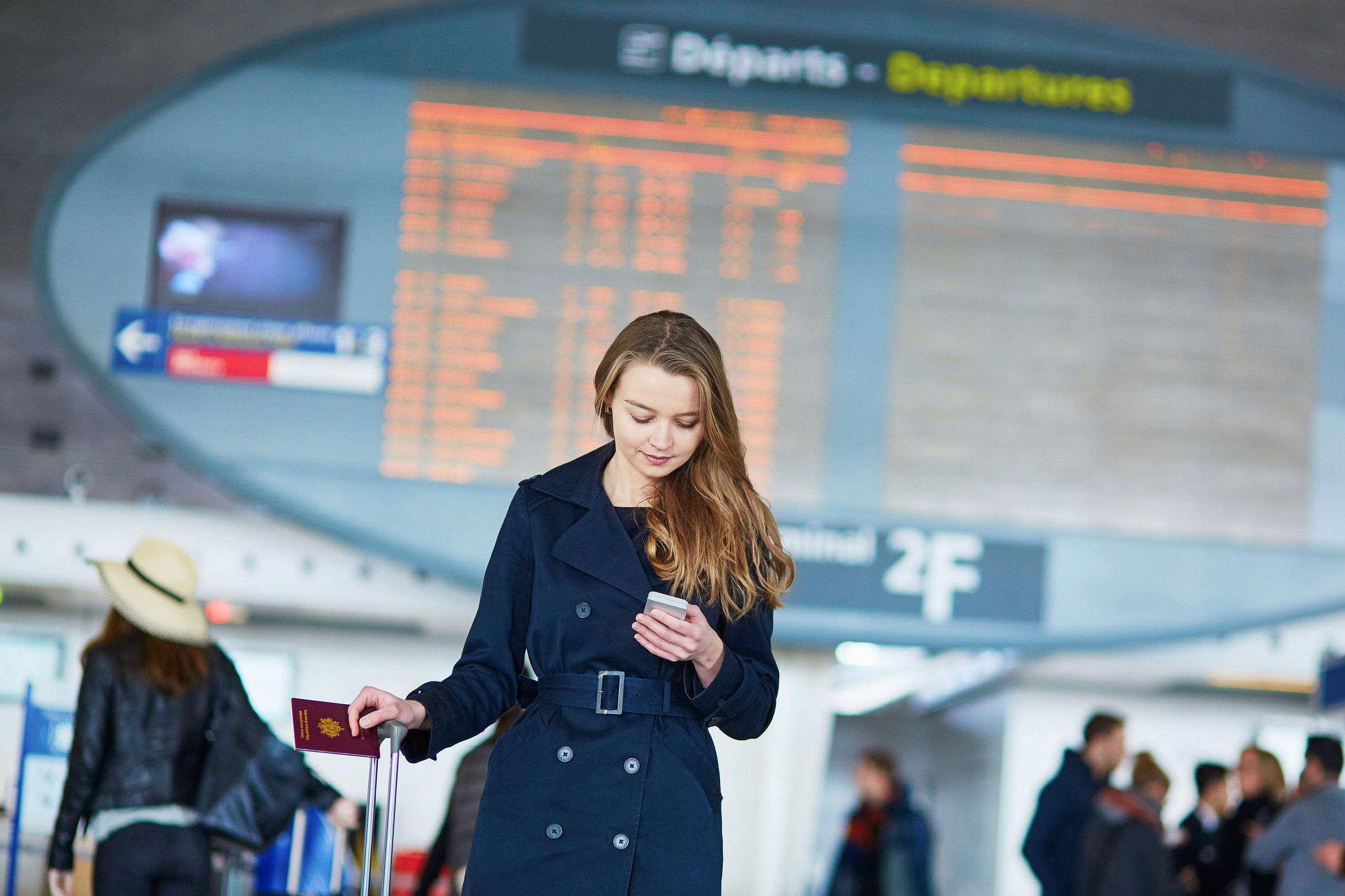 Young Woman In International Airport Near The Flight Information Board